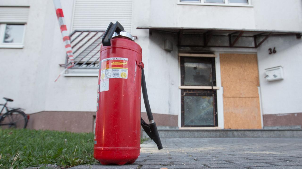 Ein benutzter Feuerlöscher steht am 04.09.2015 in Heppenheim (Hessen) im Morgengrauen vor einer Unterkunft für Asylbewerber, nachdem in der Nacht ein Brand im Treppenhaus gelöscht worden war.
