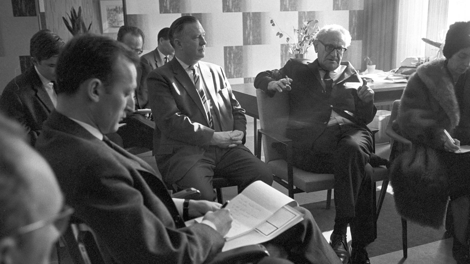 Generalstaatsanwalt Fritz Bauer (hinten mit Zigarette) auf einer Pressekonferenz im Februar 1964 in Frankfurt am Main: Bauer gab er dem israelischen Geheimdienst Mossad den entscheidenden Tipp zur Ergreifung von Adolf Eichmann in Argentinien.