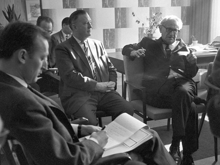 Generalstaatsanwalt Fritz Bauer (hinten mit Zigarette) auf einer Pressekonferenz im Februar 1964 in Frankfurt am Main: Bauer gab er dem israelischen Geheimdienst Mossad den entscheidenden Tipp zur Ergreifung von Adolf Eichmann in Argentinien.