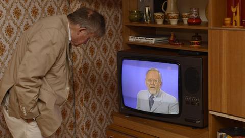 Ein Besucher des DDR-Museums blickt auf einen Fernseher in dem die Sendung "Der Schwarze Kanal" mit dessen Moderator Karl-Eduard von Schnitzler läuft.