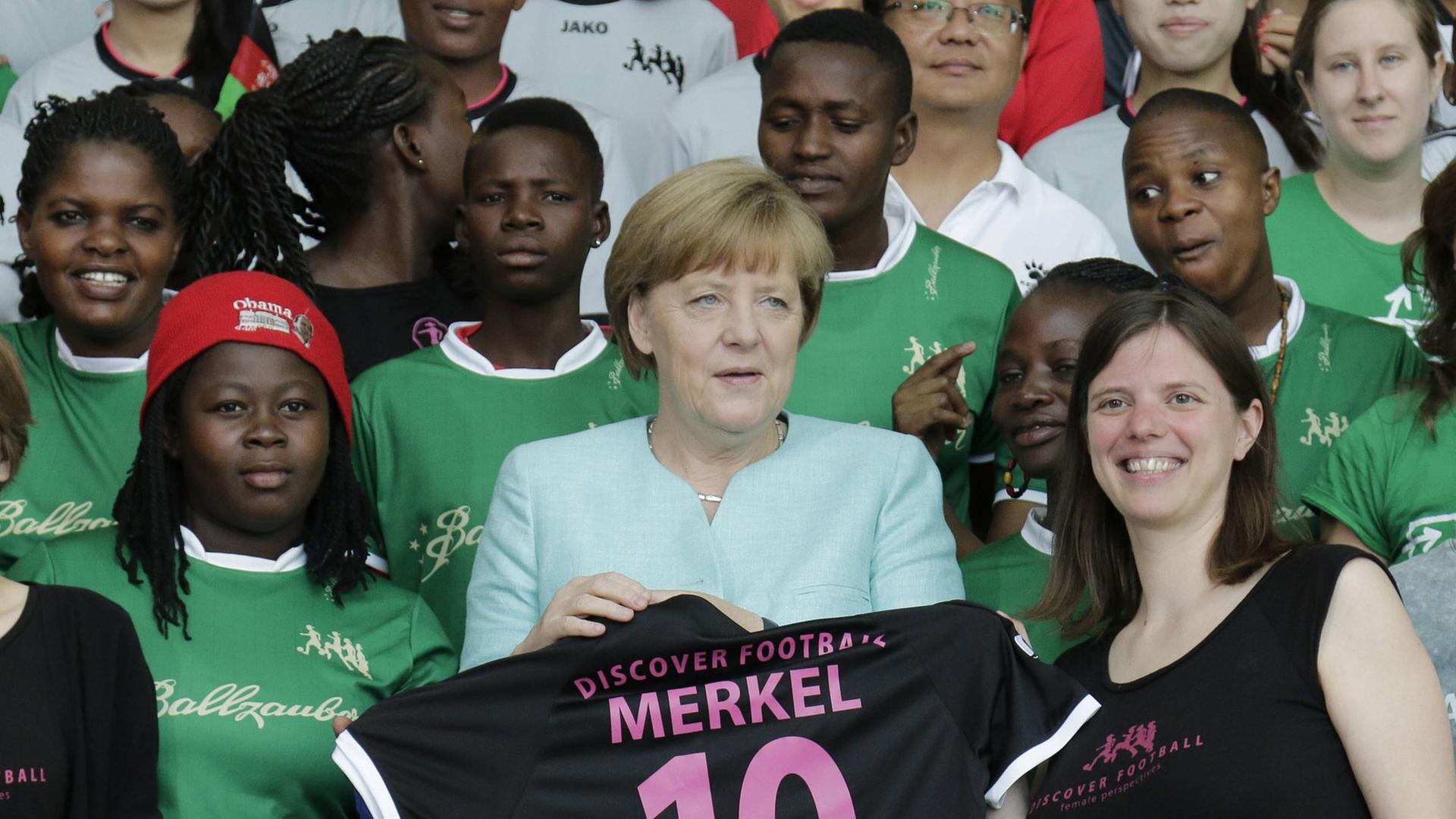 Bundeskanzlerin Angela Merkel mit Fußballerinnen des Discover Football Festivals.