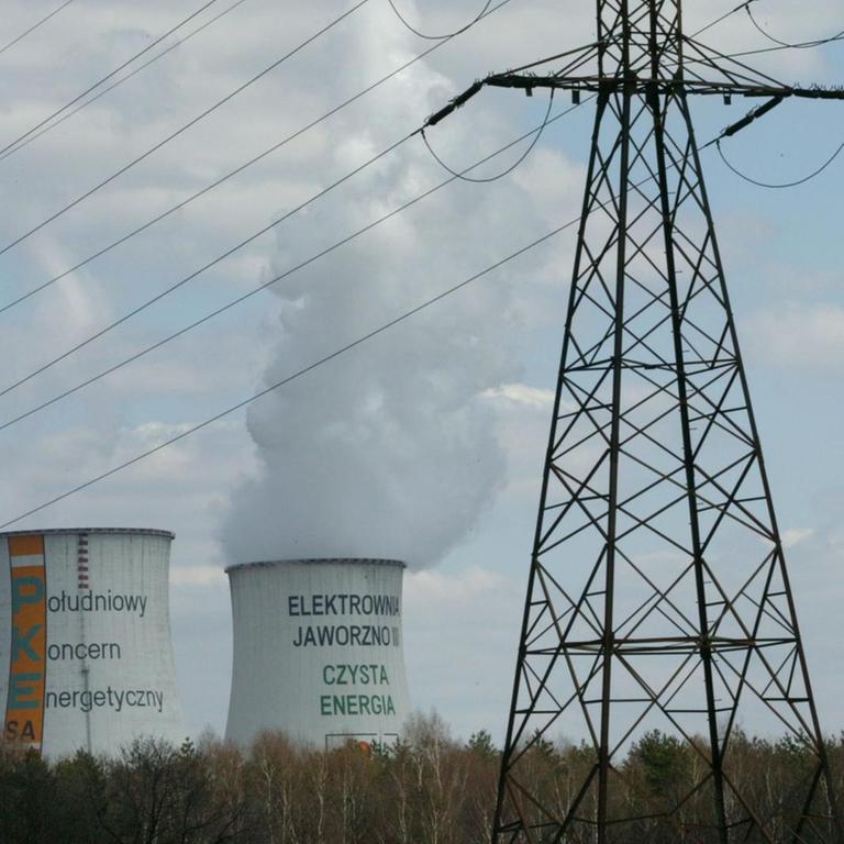 Rauchende Kühltürme des Kraftwerks des Energiekonzern Süd PKE in der Nähe von Kattowitz in einer Landschaft.