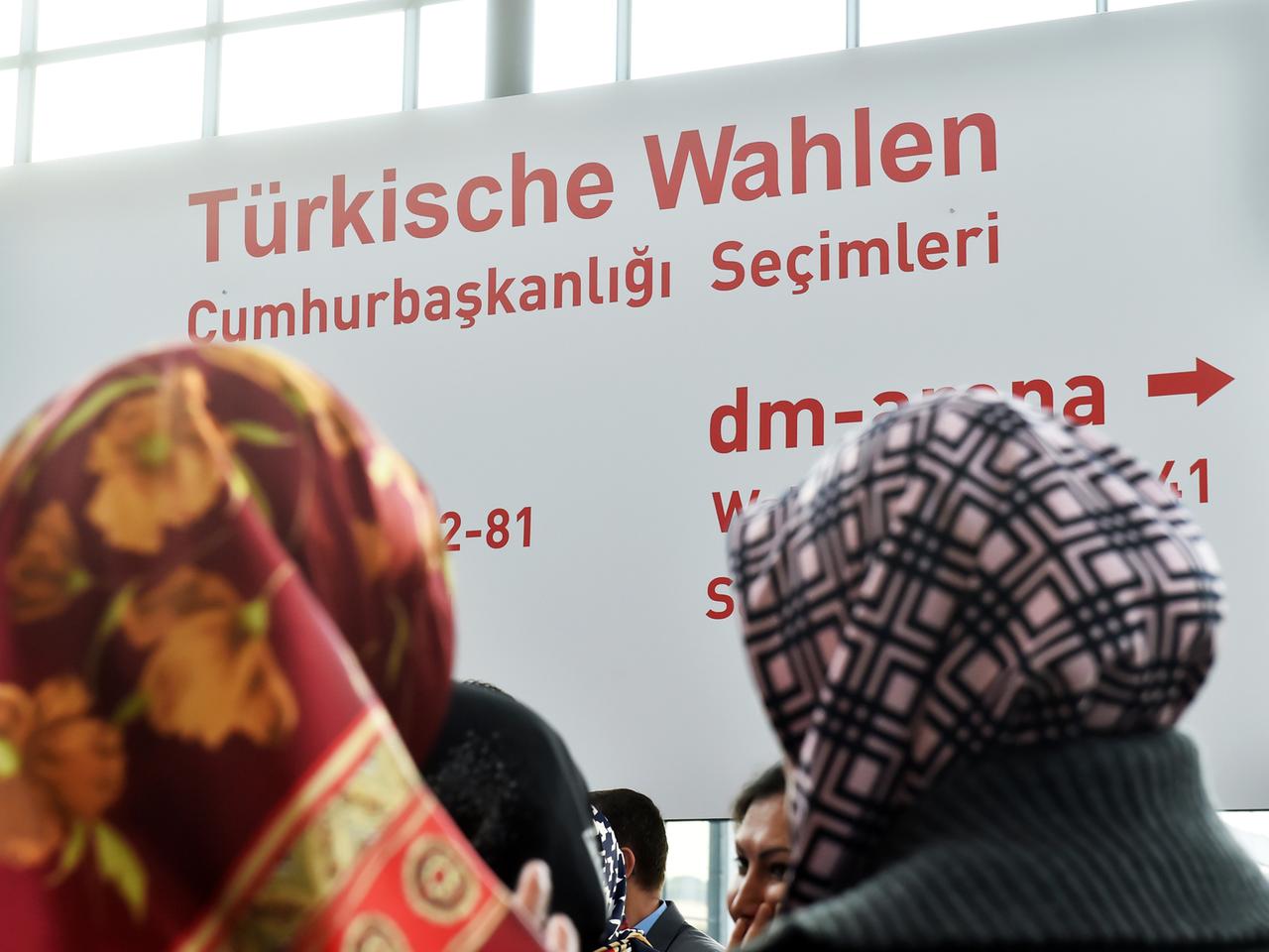 Auf dem Messegelände in Karlsruhe (Baden-Württemberg) stehen am 31.07.2014 Menschen vor einem Schild auf dem steht  "Türkische Wahlen".