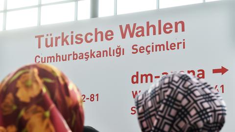 Auf dem Messegelände in Karlsruhe (Baden-Württemberg) stehen am 31.07.2014 Menschen vor einem Schild auf dem steht "Türkische Wahlen".