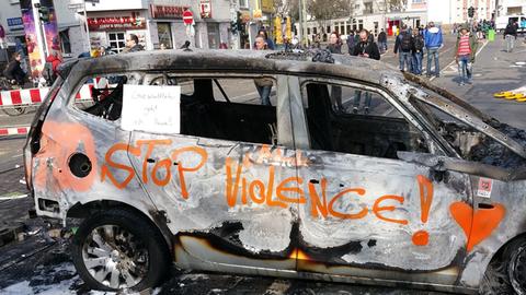 Blockupy-Proteste gegen die EZB: Ein ausgebranntes Auto mit der Aufschrift "Stop Violence"