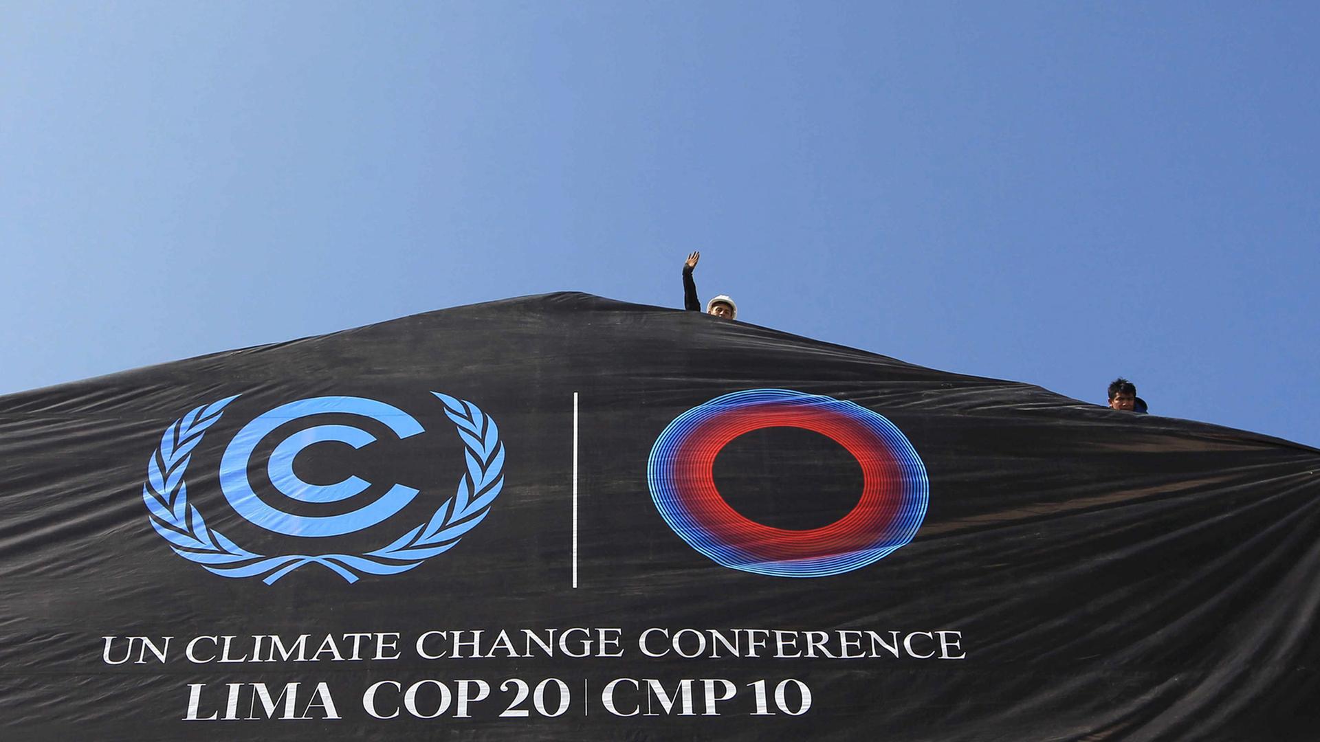 Das Logo des COP20-Weltklimagipfels in Peru als Banner auf einem Dach.