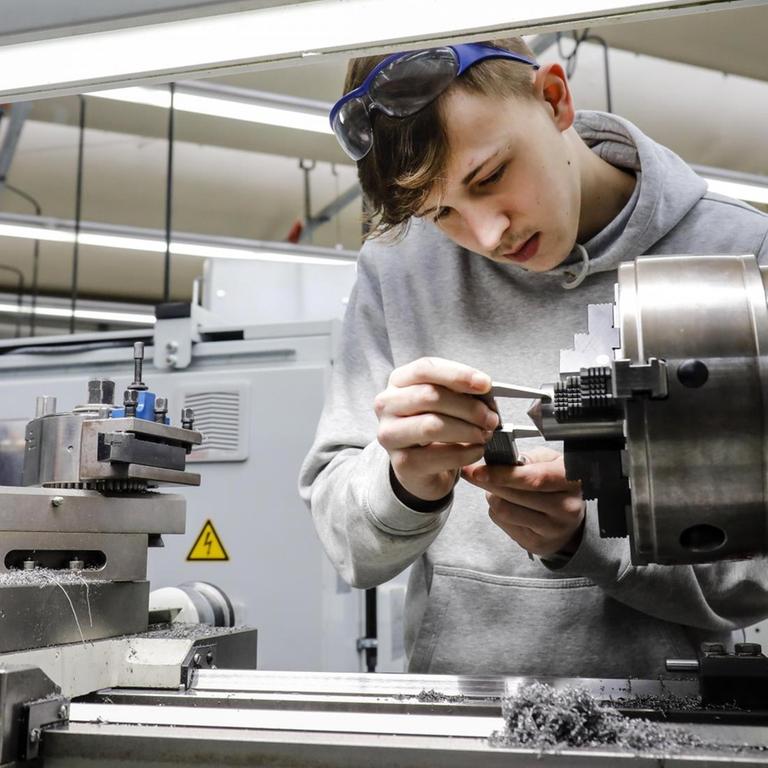 Ein Azubi steht im Berufsbildungszentrum der Remscheider Metall- und Elektroindustrie an einer Werkzeugmaschine.