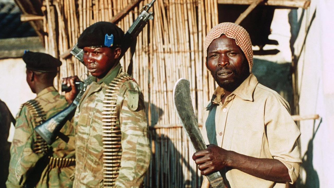 Soldaten der Regierungsarmee (l) und verbündete Hutu-Milizen (r) am 12. Juni 1994 während einer Kampfpause in der Nähe der umkämpften Stadt Gitarama.