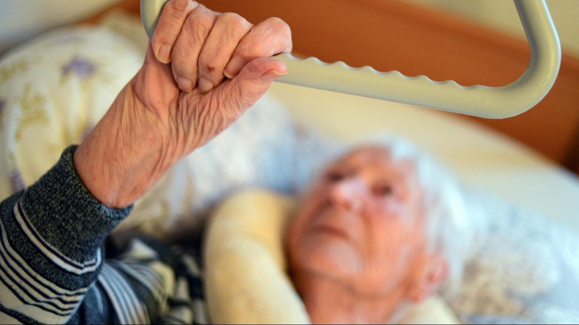 Eine pflegebedürftige Frau liegt zu Hause in ihrem Pflegebett, aufgenommen am 05.12.2013 in Potsdam.
