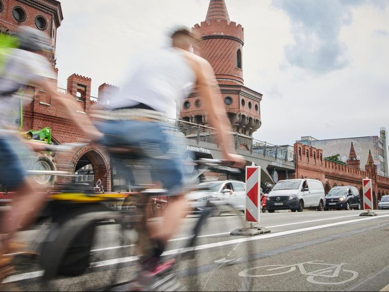 Zwei Radfahrer fahren auf dem verbreiterten Radweg auf der Oberbaumbrücke, aufgenommen am 27.07.2020 in Berlin.