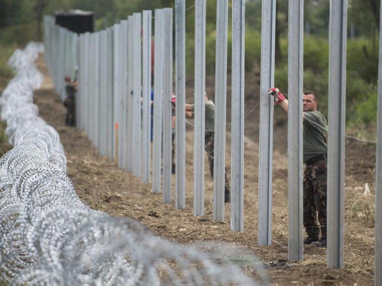 Ungarische Soldaten errichten einen temporären Zaun an der Grenze zu Kroaltien nahe Magyarboly. Aufnahme vom 24.09.2015
