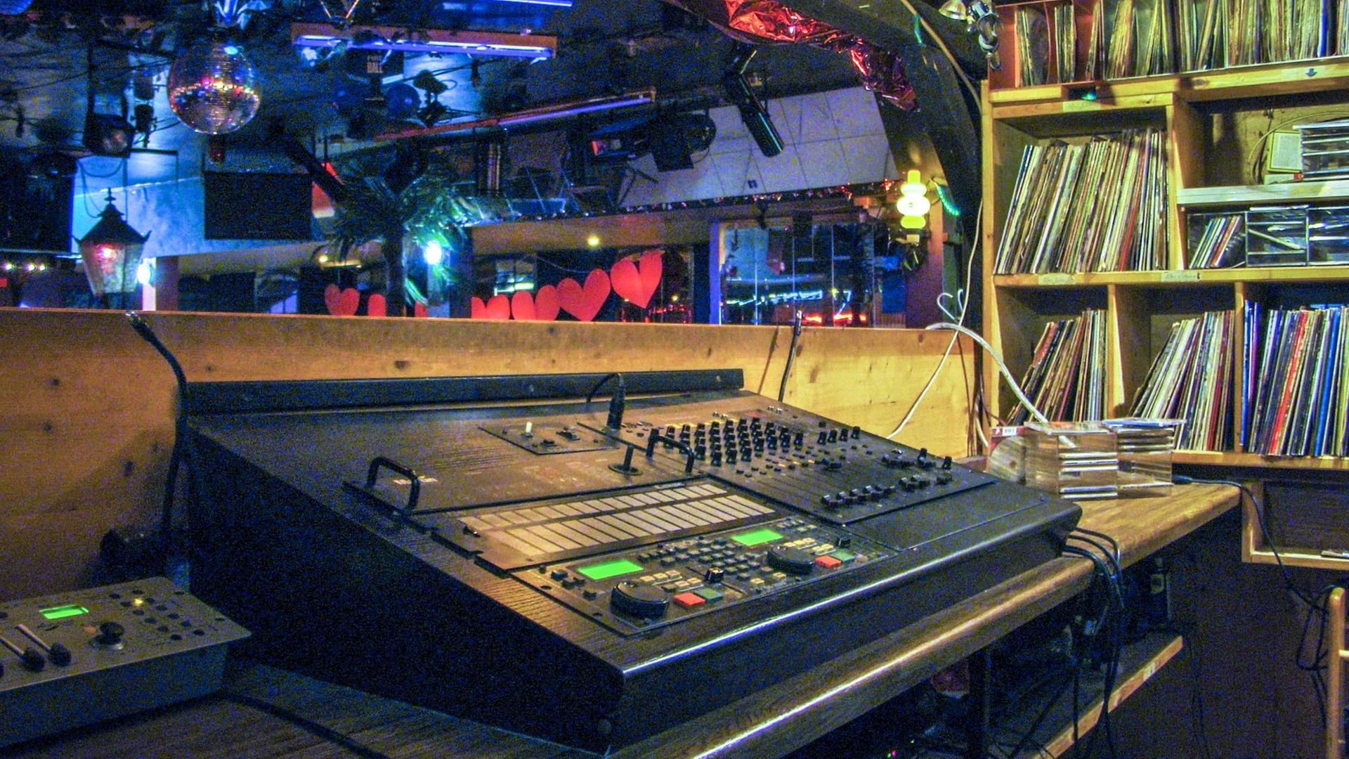 Blick aufs DJ Pult, rechts daneben der Plattenschrank, im Hintergrund die Tanzfläche.