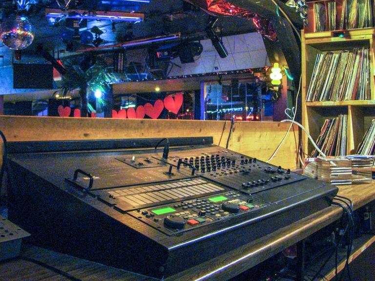 Blick aufs DJ Pult, rechts daneben der Plattenschrank, im Hintergrund die Tanzfläche.