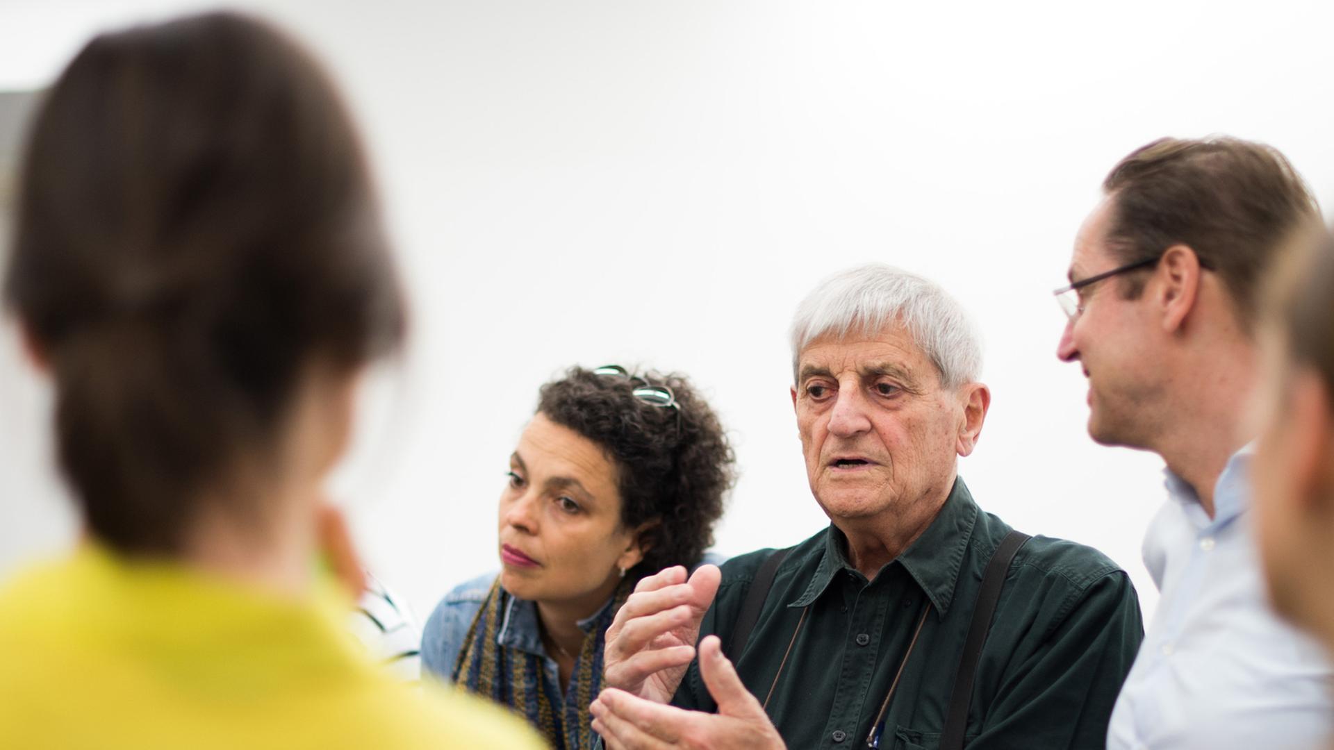 Der italienische Künstler Gianfranco Baruchello (M) spricht am 12.06.2014 in seiner Ausstellung in der Sammlung Falckenberg der Deichtorhallen in Hamburg vor Mitarbeitern des Hauses, rechts neben ihm der Intendant der Deichtorhallen Dirk Luckow. Die Schau "Gianfranco Baruchello - Certain Ideas. Retrospektive" ist vom 14. Juni bis zum 28. September in der Sammlung Falckenberg in Hamburg-Harburg zu sehen. Foto: Daniel Reinhardt