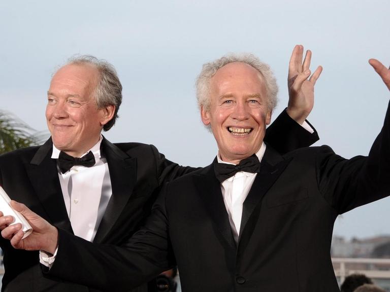 Die beiden belgischen Regie-Brüder Luc Dardenne (l) und Jean-Pierre Dardenne 2011 in Cannes: Sie winken in die Kamera.
