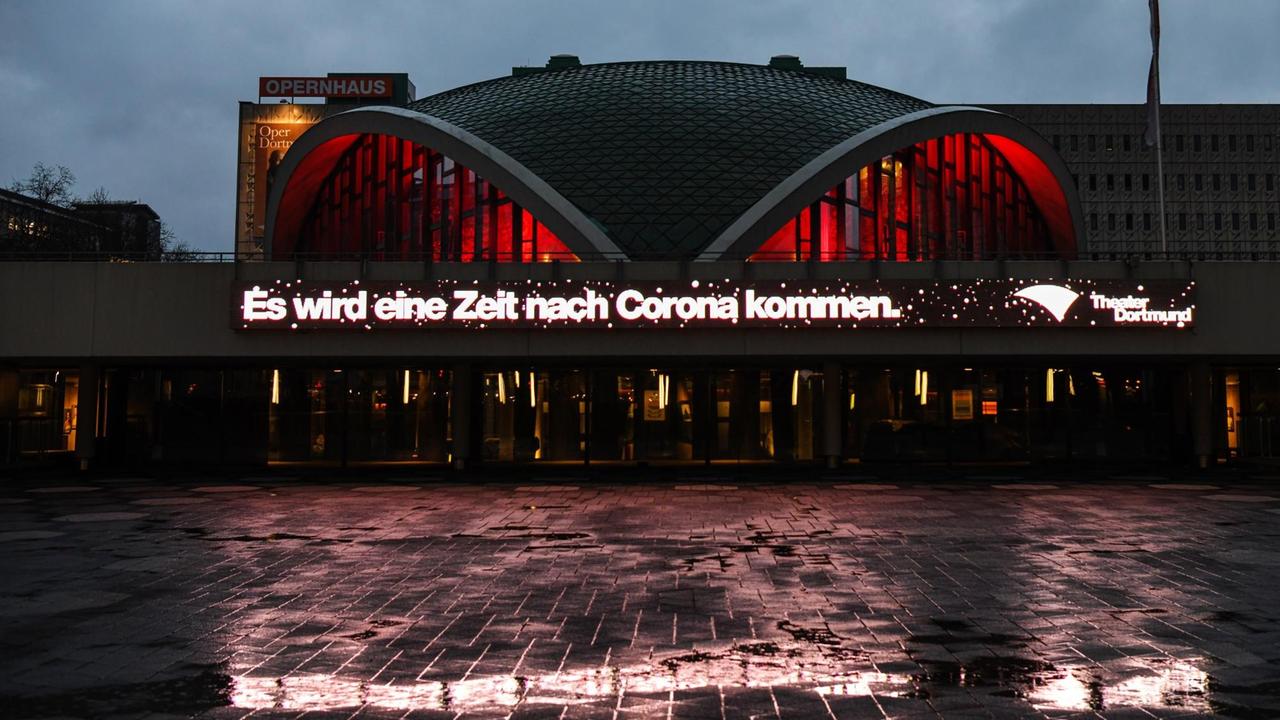 Über die ganze Breite des Gebäudes steht in roter Leuchtschrift: "Es wird eine Zeit nach Corona kommen."