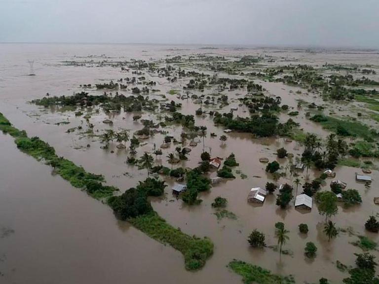 Ein vom World Food Programme aufgenommenes Bild zeigt die vom Zyklon "Idai" überschwemmte Landschaft um Nicoadala in Mosambik. Das braune Wasser reicht bis zum Horizont, es ragen Bäume, Hütten und Gebüsch heraus.