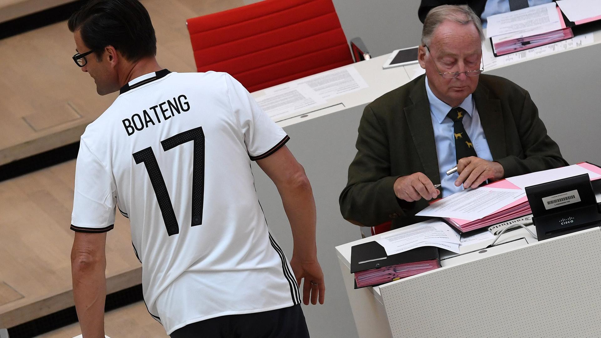 Der Abgeordnete Sven Petke, CDU, läuft am 8. Juni 2016 in einem Fußball-Shirt mit der Aufschrift "Boateng" im Landtag in Potsdam auf seinen Platz im Plenum. Rechts sitzt der Vorsitzende der AfD-Fraktion, Alexander Gauland.