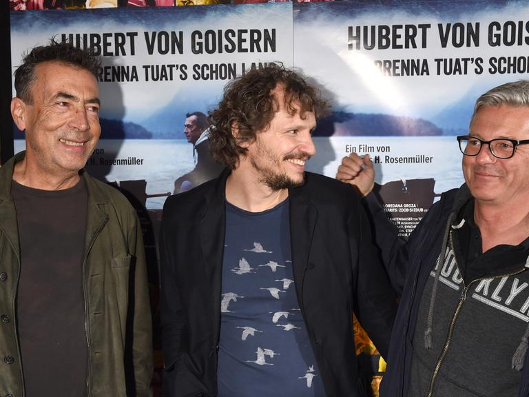 Musiker Hubert von Goisern (v.l.), Regisseur Marcus H. Rosenmüller und Markus Aicher (BR) in München (Bayern) bei der Deutschlandpremiere des Films "Hubert von Goisern - Brenna tuat's schon lang".