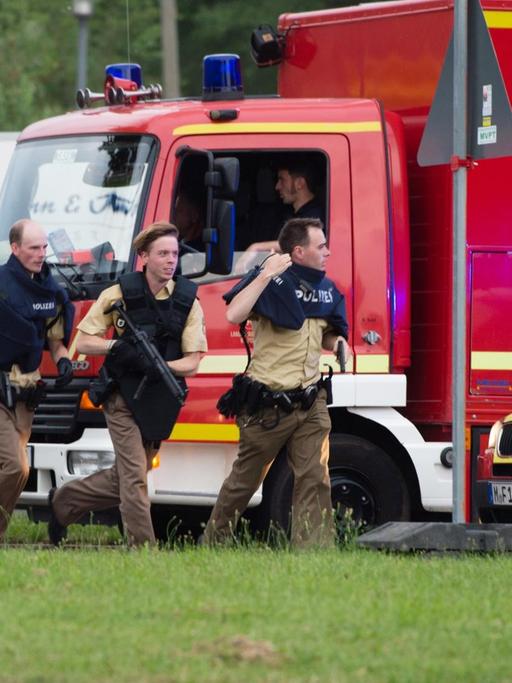 Polizisten kommen am 22.07.2016 in München (Bayern) zu dem Einkaufszentrum, in dem Schüsse gefallen sind. Bei Schüssen am Olympia-Einkaufszentrum in München hat es am Freitag nach Angaben der Polizei Verletzte und möglicherweise auch Tote gegeben.