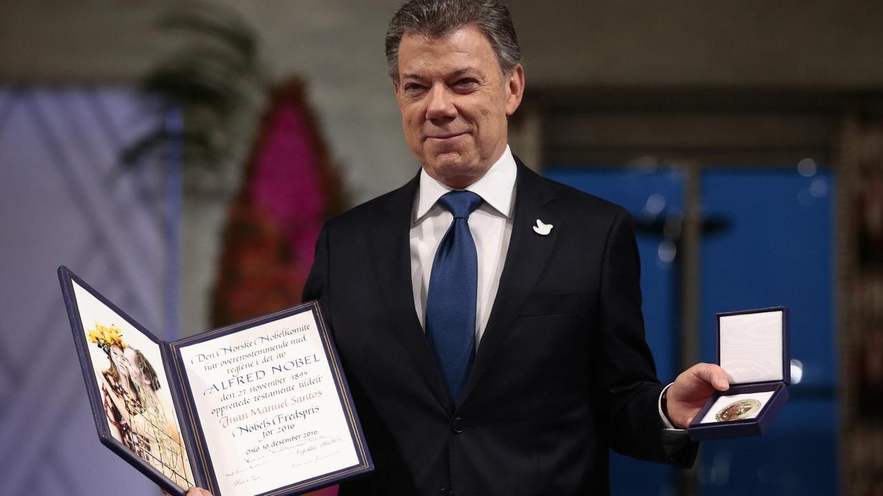 Der kolumbianische Präsident Santos zeigt in Oslo die Urkunde und die Medaille des Friedensnobelpreises 2016.
