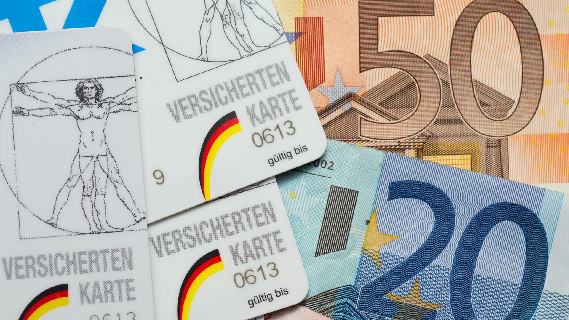 Krankenkassen-Karten liegen neben Euro-Scheinen.