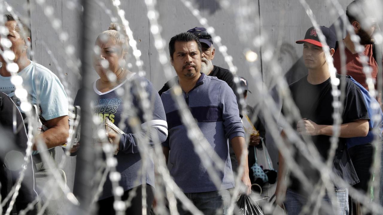 Migranten stehen am San Ysidro Grenzübergang an, um die Grenze in die USA überqueren zu können.