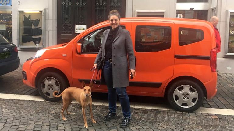 Die Städträtin Francesca Schir mit einem Hund steht in Meran vor einem Auto