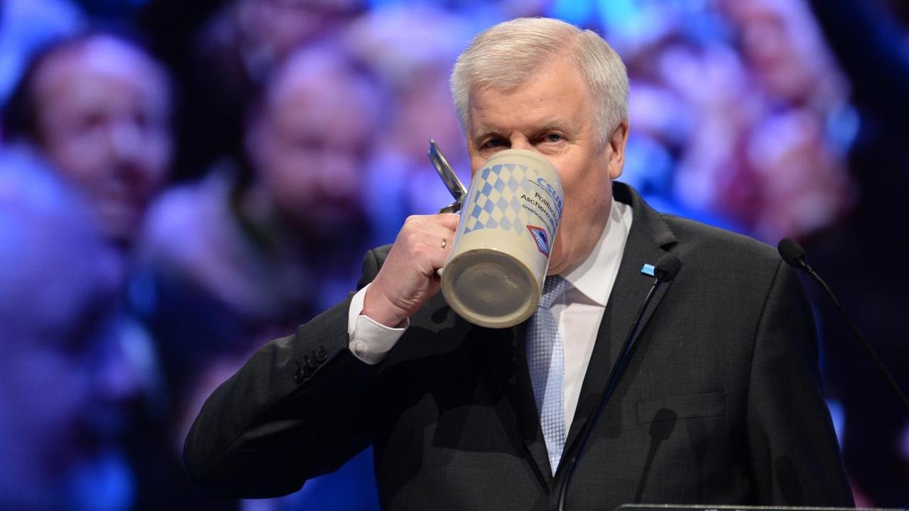 Der bayerische Ministerpräsident und CSU-Vorsitzende Horst Seehofer (CSU) trinkt auf der Bühne aus einem Maßkrug. Der bayerische Ministerpräsident und CSU-Vorsitzende Horst Seehofer (CSU) trinkt auf der Bühne aus einem Maßkrug.