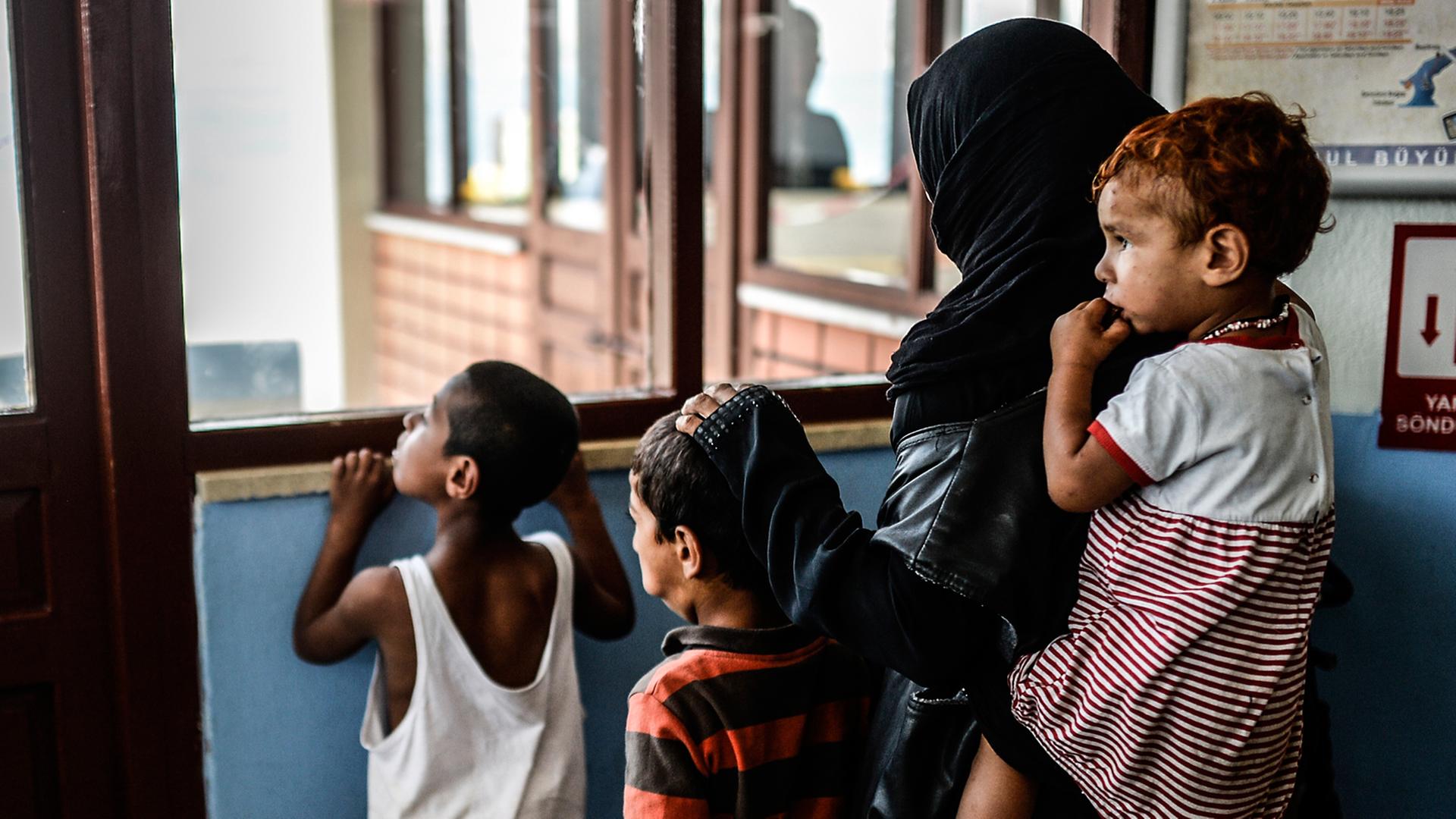 Eine Syrerin wartet in Istanbul mit Kindern auf eine Fähre