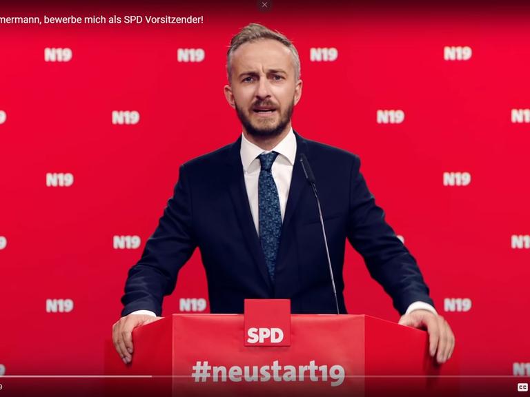 Der Screenshot zeigt den TV-Moderator und Satiriker Jan Böhmermann in einem Youtube-Video vor rotem Hintergrund an einem Rednerpult mit SPD-Logo. (Copyright Jan Böhmermann)