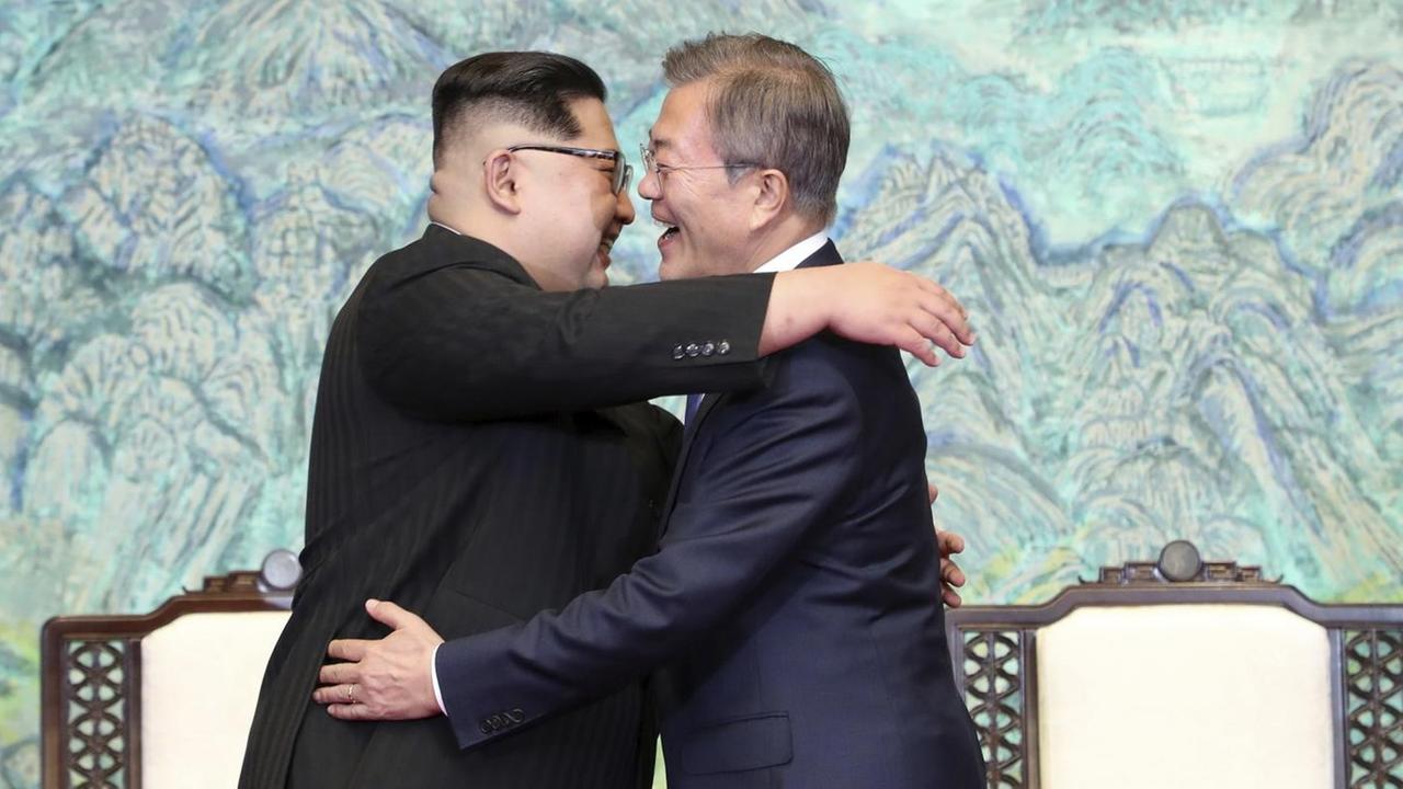 Das Bild zeigt Kim Jong Un und Moon Jae in. Sie umarmen sich.