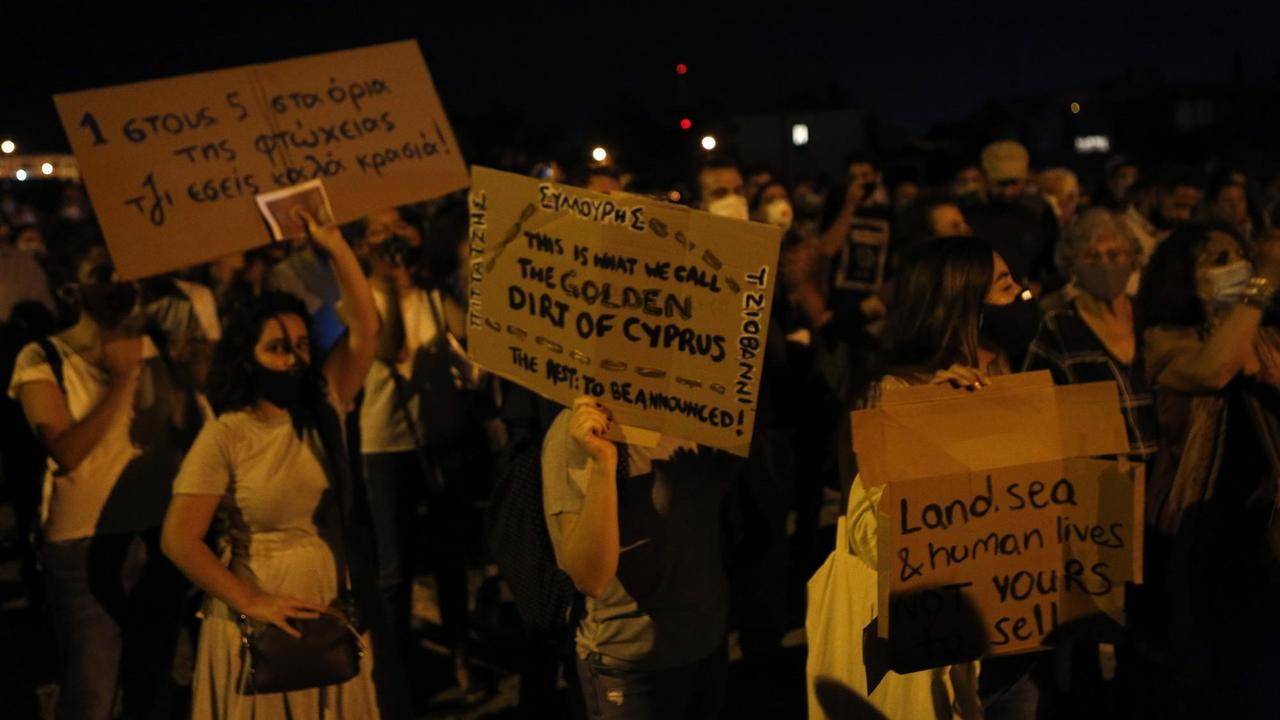 Demonstranten in Nikosia halten Plakate mit der Aufschrift "The Golden Dirt Of Cyprus" in die Höhe.