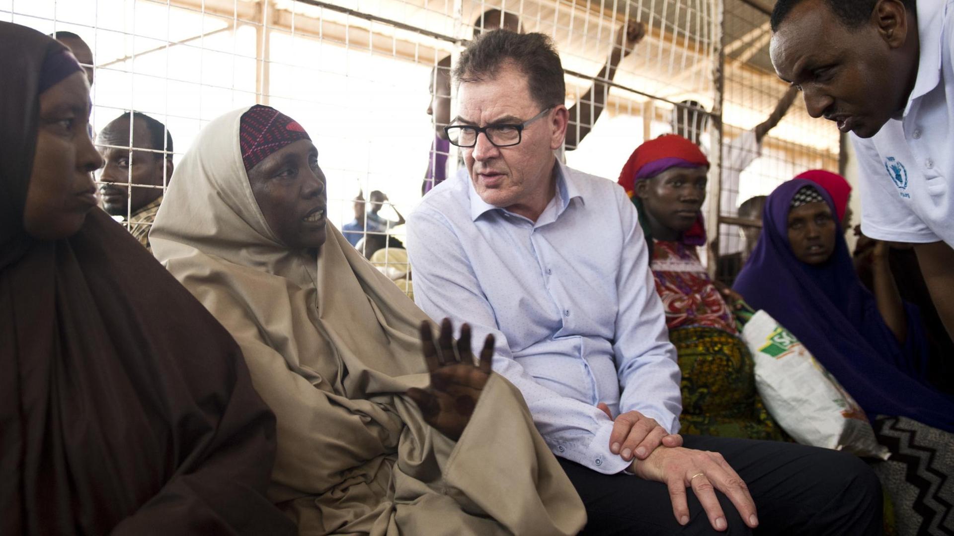 Bundesentwicklungsminister Gerd Müller (CSU) unterhaelt sich am 29.03.2016 im Fluechtlingscamp Dadaab (Kenia) in der Ausgabestelle für Nahrungsmittelrationen mit einer Frau.