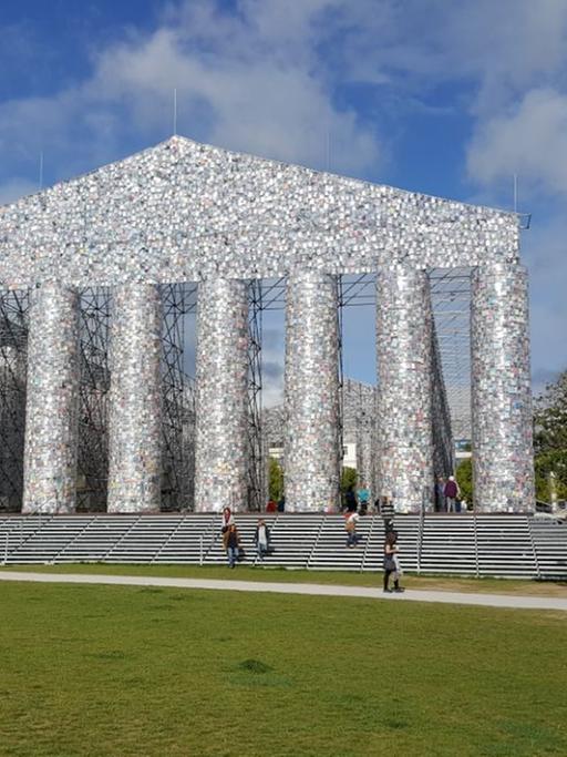 Auf einem Hügel steht ein aus Büchern zusammengesetzter Parthenon nach dem Vorbild des Parthenon auf der Athener Akropolis.