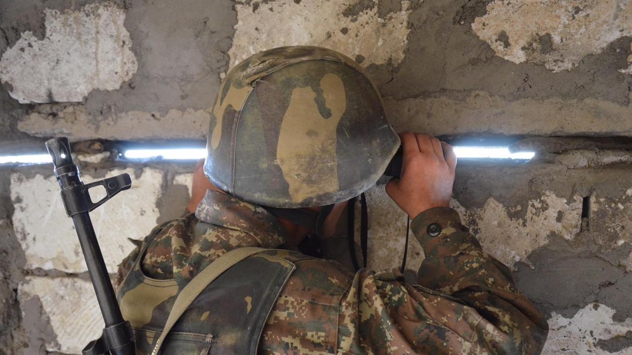Ein Soldat der Armee Berg-Karabachs beobachtet  in  einem Bunker an der Frontlinie aserbaidschanische Stellungen