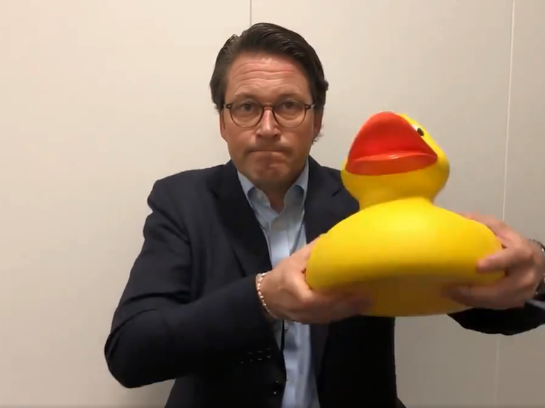 Bundesverkehrsminister Andreas Scheuer (CSU) hält eine gelbe Gummiente in die Höhe