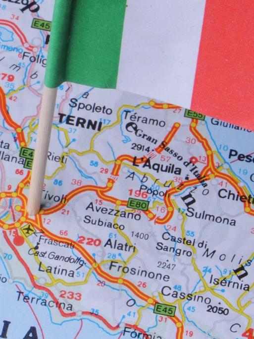 Eine kleine Italienflagge steckt in einer Landkarte