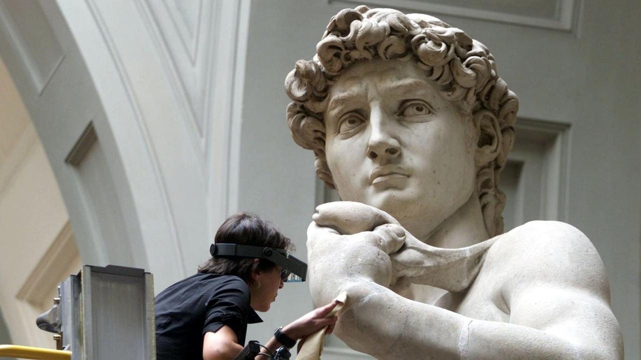 Ein Restaurator arbeitet an der Hand der David-Statue von Michelangelo in der Akademie in Florenz. 