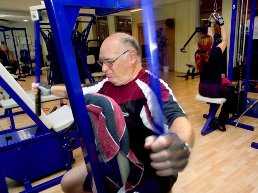 Ein älterer Mann beim ausgiebigen Training der Arme an einem speziellen Trainingsgerät.