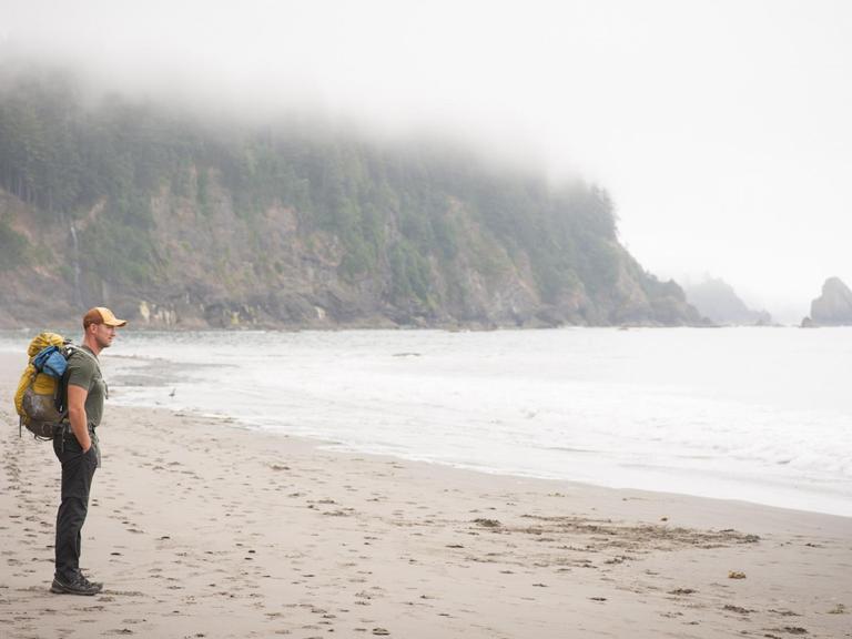 Ein Wanderer steht am Toleak Point (USA) und blickt auf das Meer.
