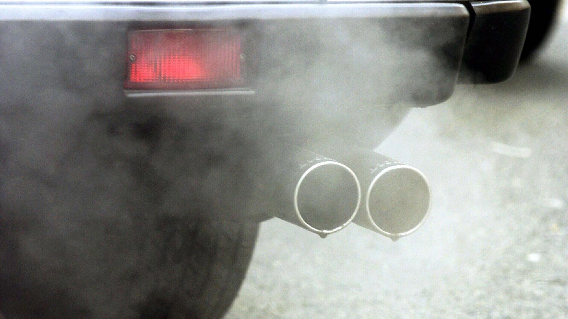 Rauch kommt aus einem Auspuff von einem Auto.