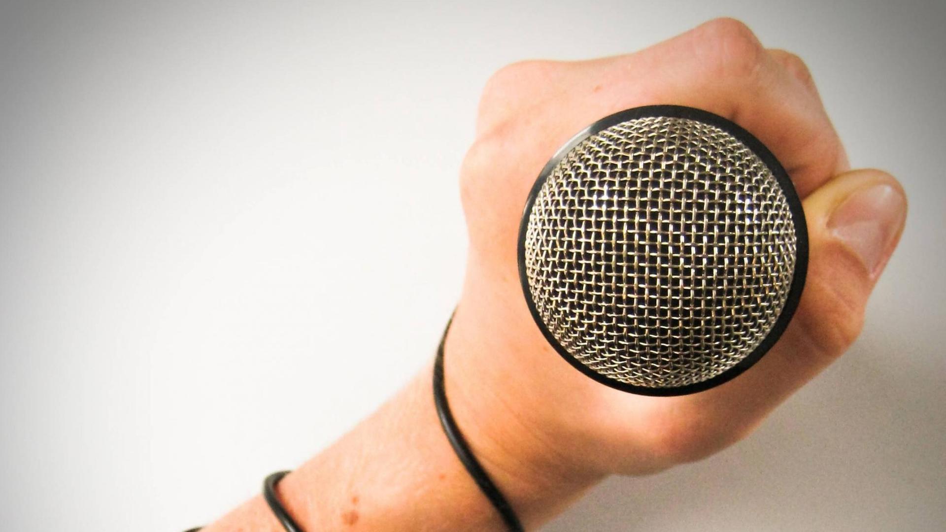 Eine Hand hält ein Mikrofon