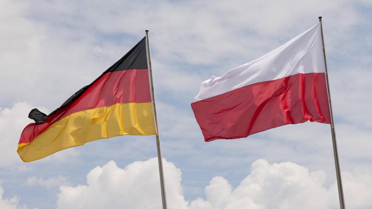 Die deutsche und die polnische Nationalflagge sind gegen den Himmel zu sehen in Berlin.