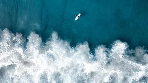 Luftaufnahme eines Surfers und Wellen