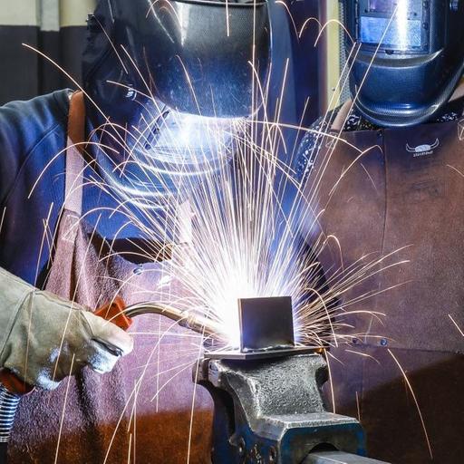 Auszubildende mit Schutzmasken beim Schweißen.