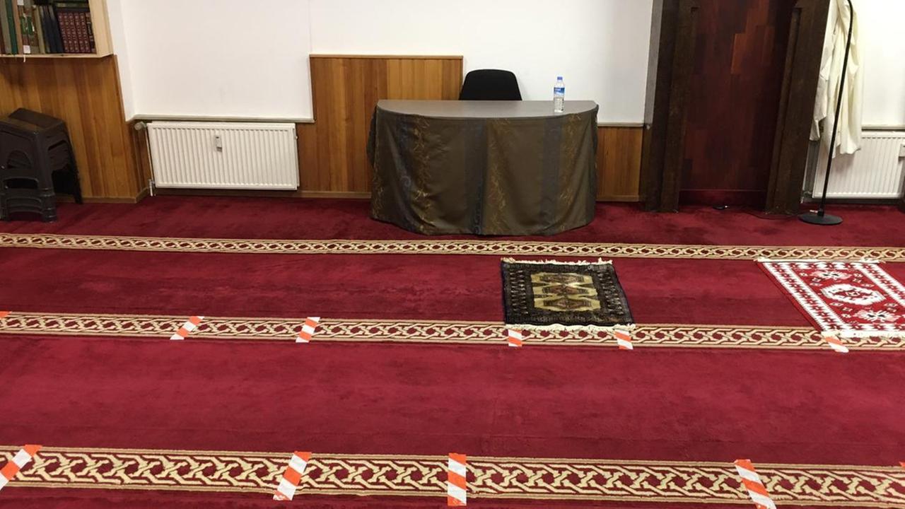 Rot-weiße Klebestreifen markieren im Gebetsraum der El-Iman-Moschee in Hamburg, wieviel Abstand die Gläubigen beim Gebet voneinander halten sollen.