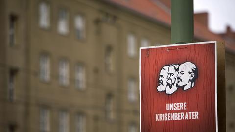 Ein Wahlplakat der Deutschen Kommunistischen Partei (DKP) mit der Abbildung von Karl Marx (l-r), Friedrich Engels und Wladimir Iljitsch Uljanow (Lenin) und der Aufschrift "Unsere Krisenberater".