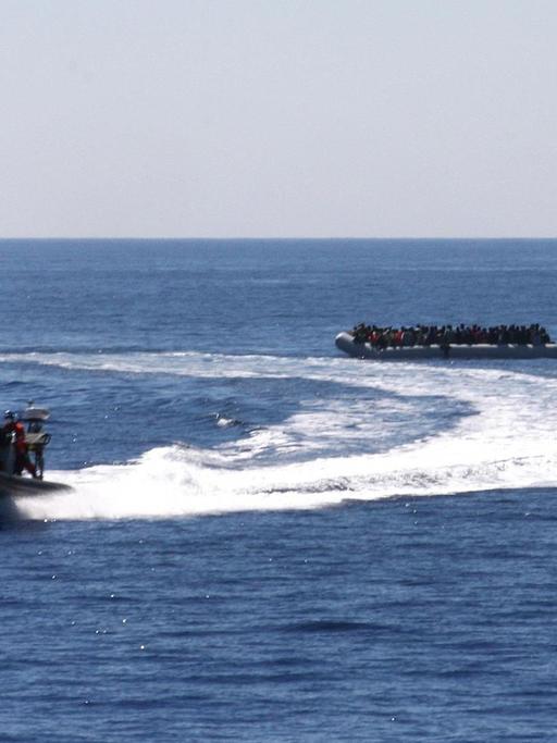 Ein Speedboat und ein Fast Rescue Boat begleiten am 14.05.2015 ein Schlauchboot mit schiffbrüchigen Flüchtlingen zur Fregatte Hessen.