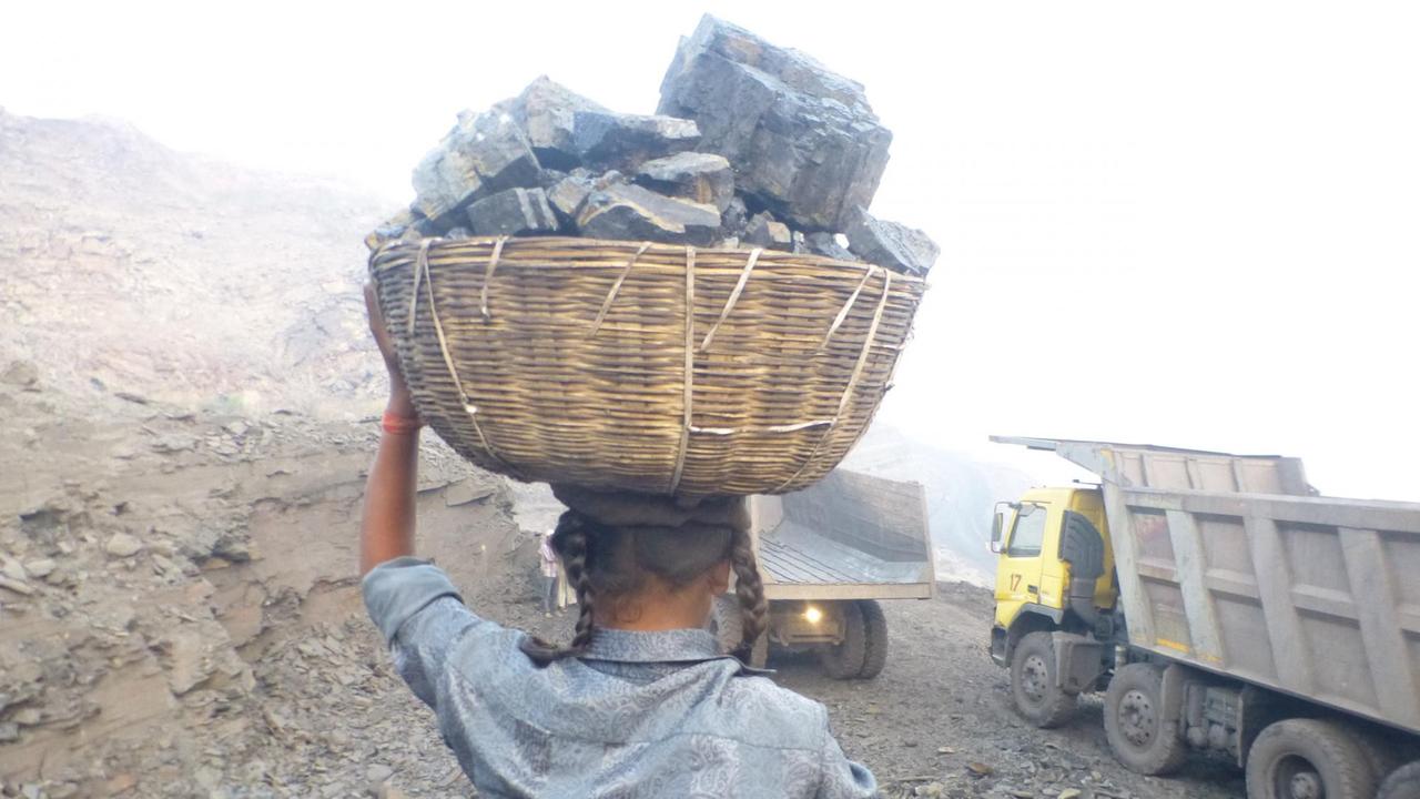 Shivani beginnt den Rückweg mit schwerem Korb auf dem Kopf.